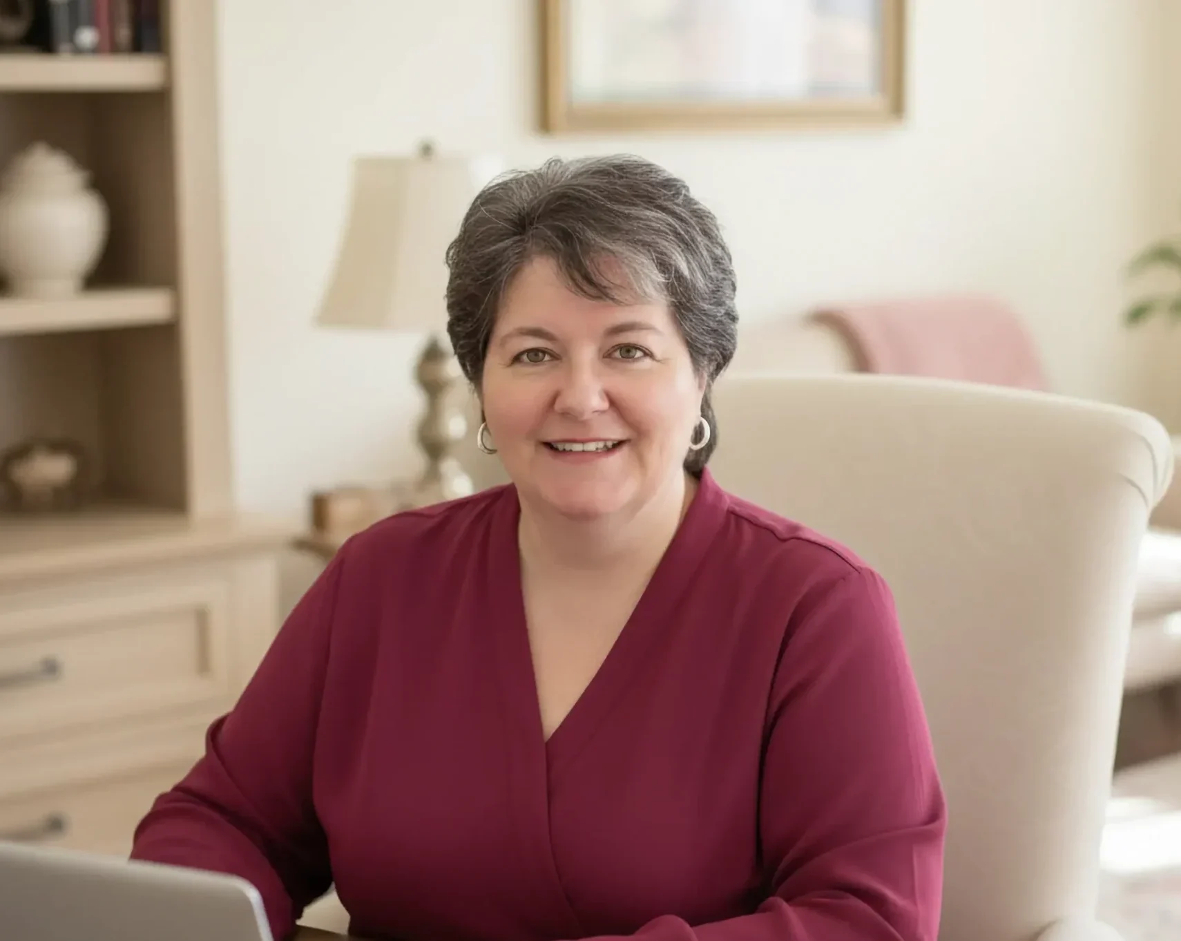 Smiling woman at desk with laptop