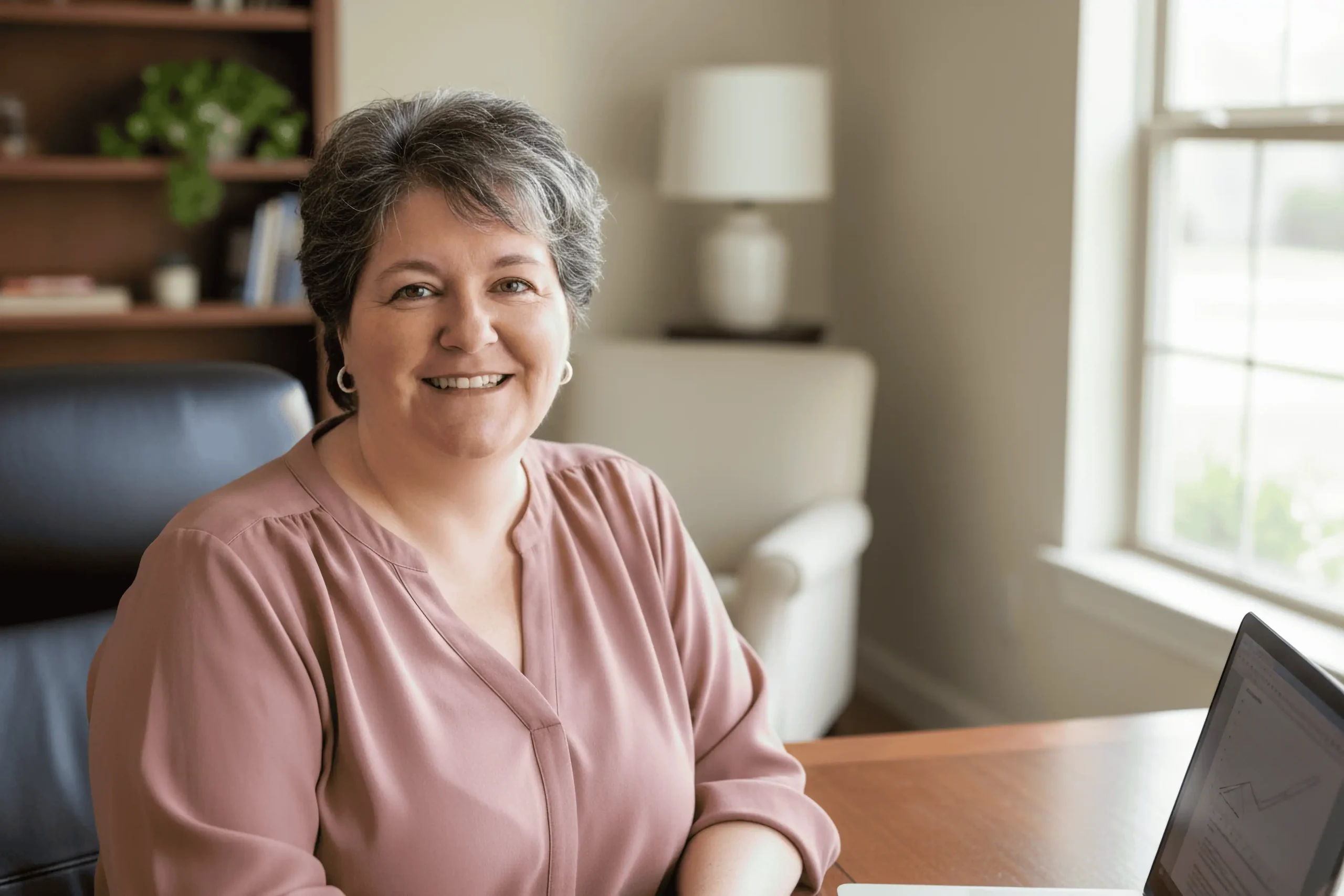 Smiling woman at desk with laptop